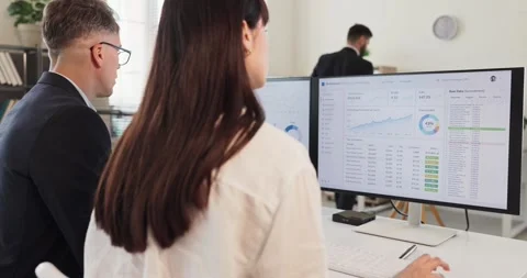 Analysts teamwork on finance data dashboards in modern office, monitoring charts Stock Footage 341858457