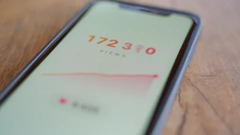 Analytics app on smartphone showing rising view counter and growth chart on a Stock Footage 342910238