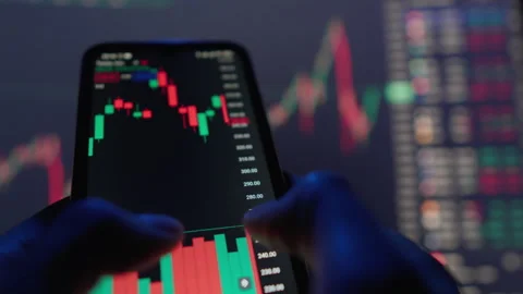 Analyze stock market trends using candlestick charts on mobile devices to Stock Footage 283207976