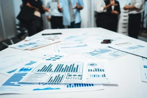 Analyzed financial data visualized papers on meeting table. Prudent Stock Photos