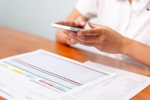 Analyzing business reports mobile device home office digital content focuse.. Stock Photos