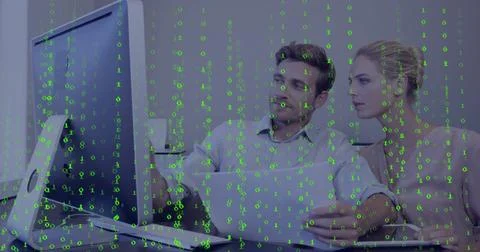 Analyzing colleagues collaborating at office desk with monitor, laptop and mug, Foto stock