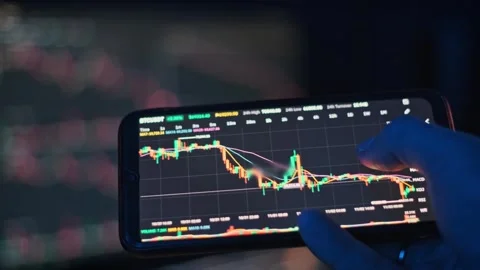 Analyzing Crypto Charts on Phone Stock Footage 303864554