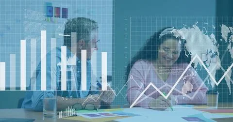 Analyzing data charts and graphs image over colleagues collaborating in office 写真素材