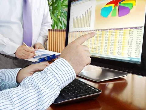 Analyzing data on computer Analyzing financial data and charts on computer... Stock Photos