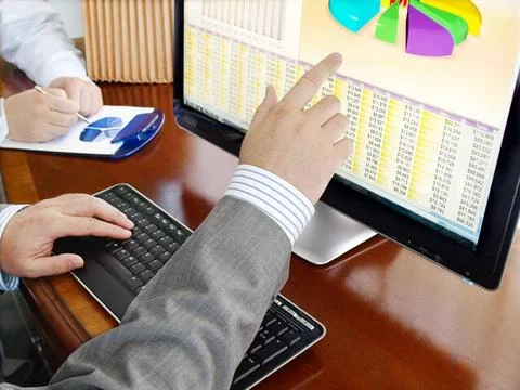 Analyzing data on computer Analyzing financial data and charts on computer... Stock Photos
