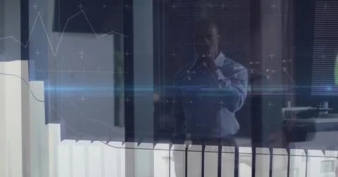 Analyzing data display businessman standing behind glass partition in corporate Stock Photos