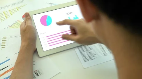 Analyzing Data on a Tablet with Charts and Reports Stock Footage 315781441