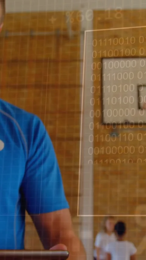 Analyzing data on tablet, coach in gym with binary code animation over hoop Stockbeeldmateriaal 342997343