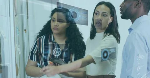 Analyzing data team wearing business attire using glass panel in office, hold Stock Photos