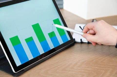 Analyzing data trends on a digital tablet with advanced graph visualization.. Stock Photos
