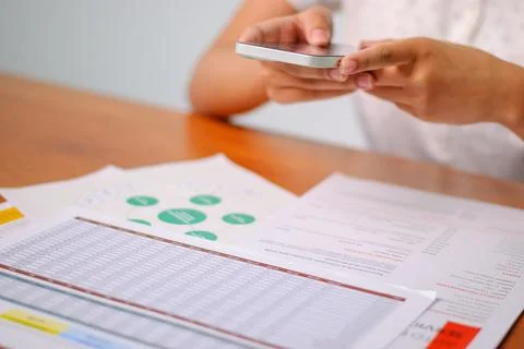Analyzing data trends with smartphone office digital reports indoor close-u.. 스톡 사진