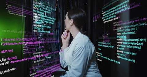 Analyzing female specialist reviewing code in data center with display panels, Foto stock