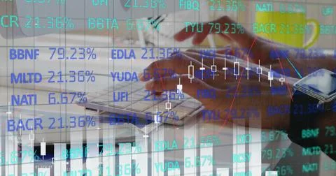 Analyzing financial data on computer with stock market graphs overlaying screen 스톡 사진