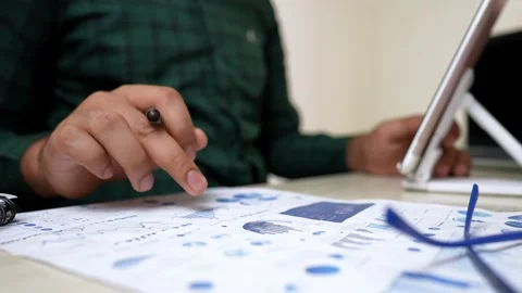 Analyzing Financial Data on Tablet and Paper Stock Footage 317737153
