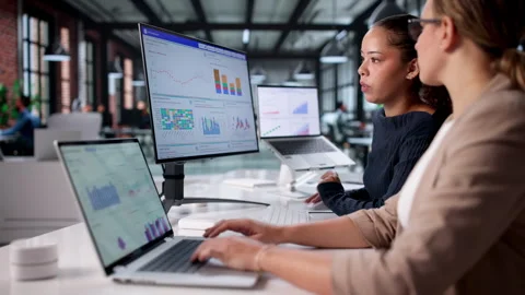 Analyzing Financial Performance: Female Analyst Monitors Data Dashboard Stock Footage 326938403