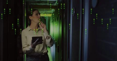 Analyzing IT engineer in jeans holding tablet in server corridor, with racks Foto stock