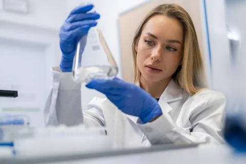 Analyzing liquid samples in a sterile laboratory environment by experienced Fotos Stock
