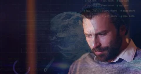 Analyzing man in knit cap, sweater studying screen with globe, code and HUD Stock Photos