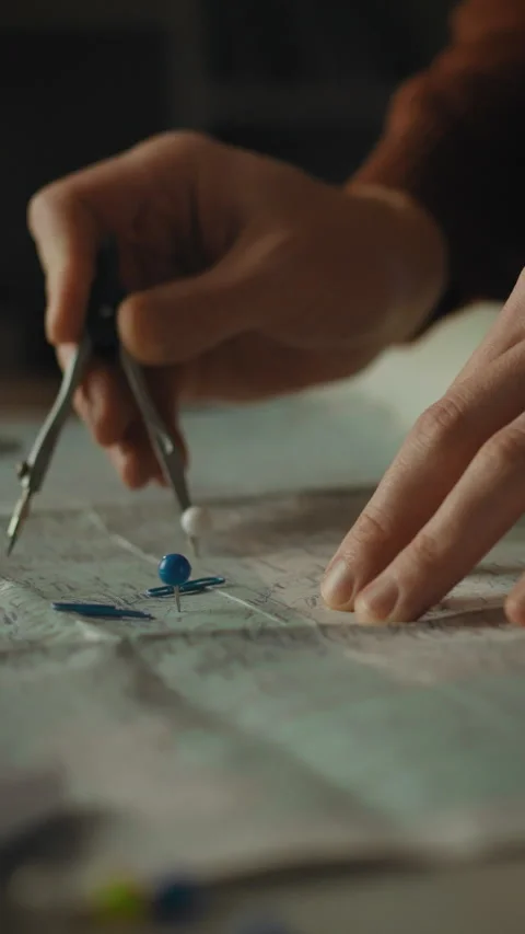 Analyzing a map with precision tools in a dimly lit room for careful plannin Stock Footage 331534573