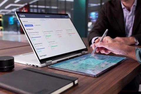 Analyzing Market Trends Using OKR Dashboard In Financial Analyst's Office. Stock Photos