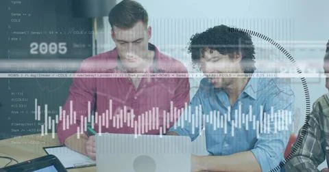 Analyzing men in maroon and blue shirts leaning over silver laptop at office Stock Photos