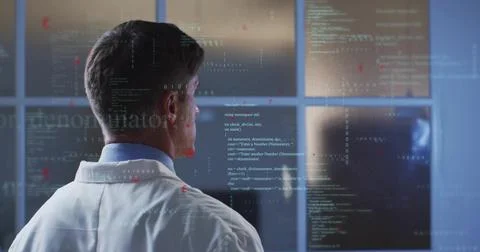 Analyzing researcher in lab coat in control-room viewing code on glass with Stock Photos