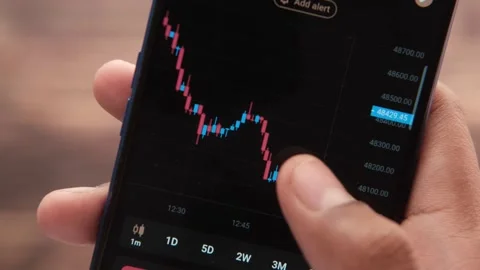 Analyzing stock chart on smart phone at night Stock Footage 166740325