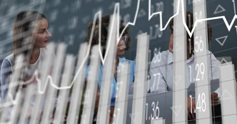 Analyzing team discussing financial data at table with laptop, wearing blue Stock Photos
