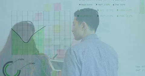 Analyzing two analysts in business attire reviewing board at office, with tablet Stock Photos
