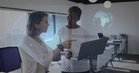 Analyzing two colleagues interacting over laptop in office, with world map and Stock Photos