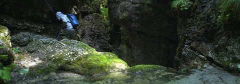 Anamorphic Lens 6K - Boy exploring the underground waterfalls Stock Footage 341642417