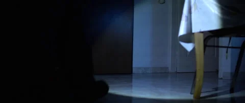 Anamorphic shot 1.33x - Man close door and leaves a dark room with a flashlight Stock Footage 160538454