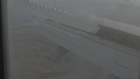 Anamorphic shot of airplane wing clouds land planet earth window view Stock Footage 118858686
