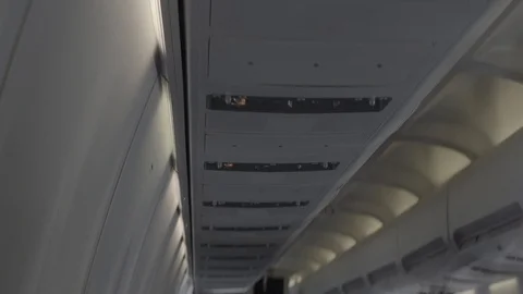 Anamorphic shot inside airplane internal interior luggage cabins air passengers Stock Footage 118883526