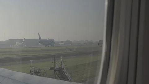 Anamorphic shot view from airplane window aircraft driving on runway run track Stock Footage 118884077