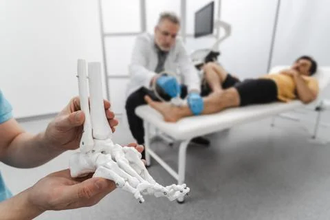 Anatomical model of foot bones on background of process of diagnostics of i.. Stock Photos
