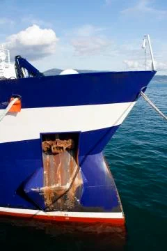 Anchor and draft marks on the bow hull of a moored ship in the dock. Stock Photos