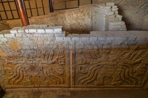 Ancient adobe corridor with polychrome relief murals of the Decapitator deity at Stock Photos
