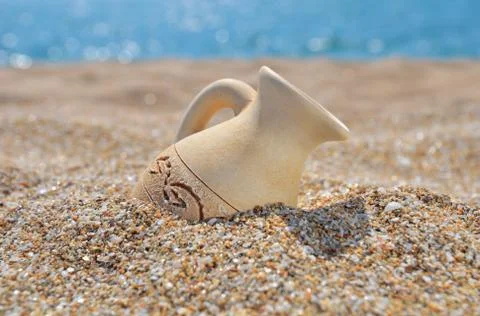Ancient amphora on the beach sand Stock Photos