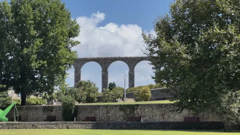 Ancient aqueduct over green grass and blue sky with clouds Vila do Conde 動画素材 209305617