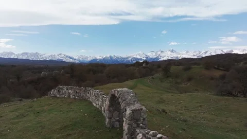 Ancient Arch and Tombs Amidst Mountain Peaks Stock Footage 304512969