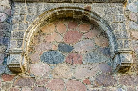Ancient arch on the stone wall of the old castle Stock Photos