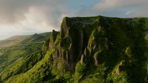 Ancient basalt ramparts draped in vibrant, windswept greenery, standing in 库存影片 336263020