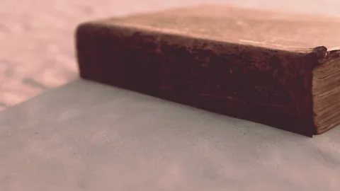 Ancient Book Resting on Delicate Parchment in Soft, Warm Light Stock Footage 344910105