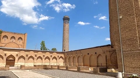 Ancient brick minaret and courtyard at Bibi-Khanym mosque in Samarkand Vidéo 336846199