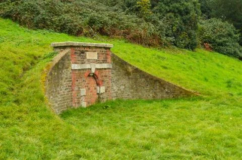 Ancient bridge in a meadow with red bricks Stock Photos