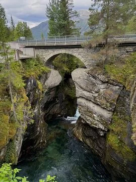 An ancient bridge under which a river flows Stock Photos