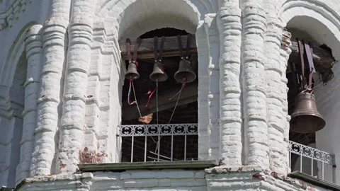 Ancient Bronze Bells Ringing Rhythmically in a White Stone Belfry Tower Stock Footage 345555837
