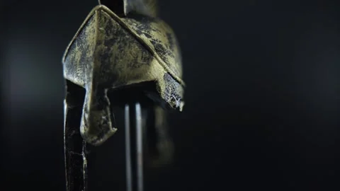 Ancient bronze gladiator helmet on rotating stand, cinematic macro shot with Stock Footage 334136822